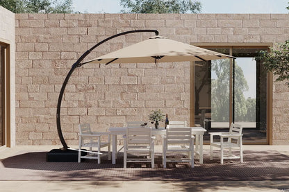 Outdoor patio set with a large umbrella and chairs in front of a stone wall.