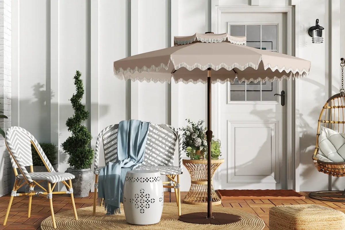 Beige outdoor umbrella on a patio with chairs and decor
