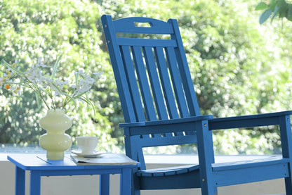 Blue chair with a small table and cup on a blurred green outdoor background