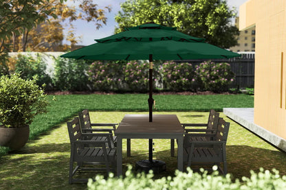 Outdoor patio set with table and chairs under a green umbrella on a grassy area.