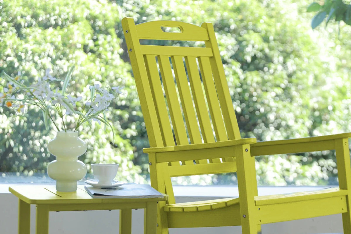 Yellow wooden chair with a small table and decorative items on a blurred green outdoor background