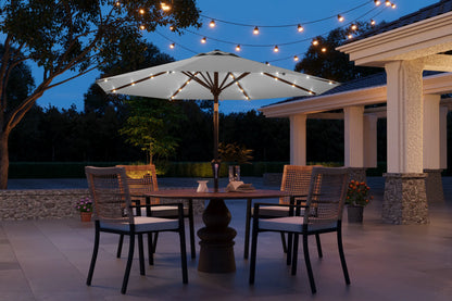 Outdoor patio setting with a table, chairs, and string lights under a large umbrella.