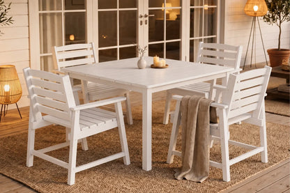 White outdoor dining set with table and 4 chairs on a wooden deck.