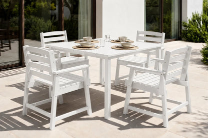 White outdoor dining table with four chairs on a patio