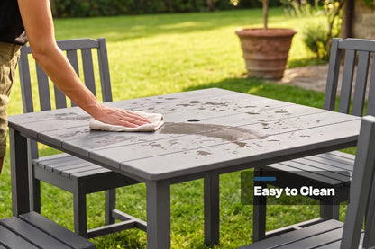 Person cleaning a gray outdoor table with 4 armless chairs in a garden setting, emphasizing ease of cleaning.