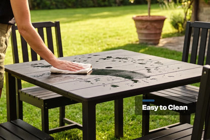 Person cleaning a black outdoor table with 4 armless chairs in the background