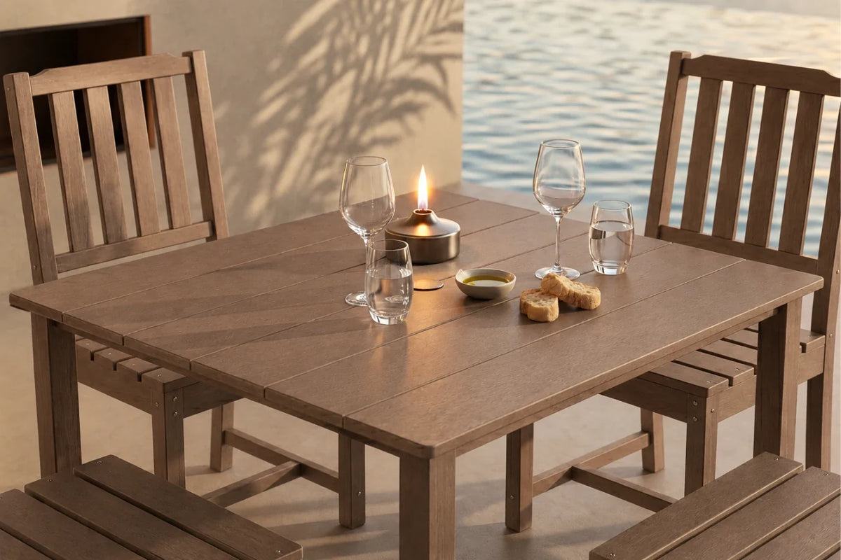 Brown outdoor dining set with table and 4 armless chairs by a body of water.