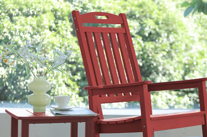 Red wooden chair with a small table and decorative items on a blurred green outdoor background