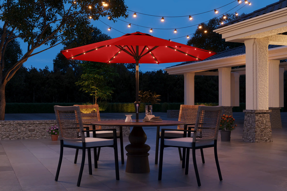 Outdoor patio setting with a red umbrella, table, and chairs under string lights.