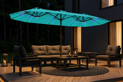 A large outdoor patio umbrella with glowing aruba blue RGB LED lights on a deck at night, surrounded by a patio sofa, two armchairs, and lanterns.