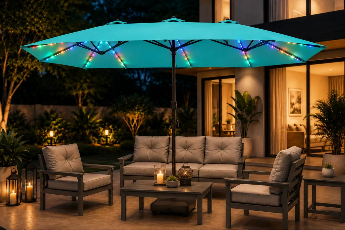 A large patio umbrella with built-in multicolor RGB LED string lights glowing along the canopy, shading an outdoor patio setup with a gray sofa, two armchairs, and a coffee table at night.