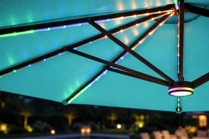 RGB LED light strips mounted along the underside of a patio umbrella, casting colorful blue, green, and warm white light onto the canopy and surrounding dark outdoor background at night.