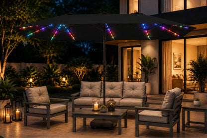Outdoor patio furniture set under a large black patio umbrella decorated with multicolor RGB LED string lights, set in a modern backyard at night.