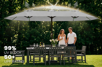 A large gray patio umbrella shading a backyard dining set, with a couple standing underneath as sunlight shines overhead. Text on the left highlights "99% UV BLOCK" and "UPF 50+ RATING".