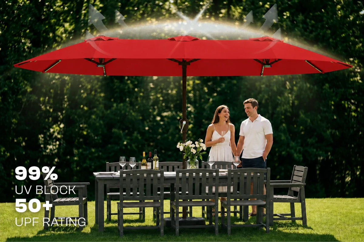 A large red patio umbrella shown on a lawn with a dining table and chairs, and a couple standing underneath. Text on the left reads '99% UV BLOCK 50+ UPF RATING'.