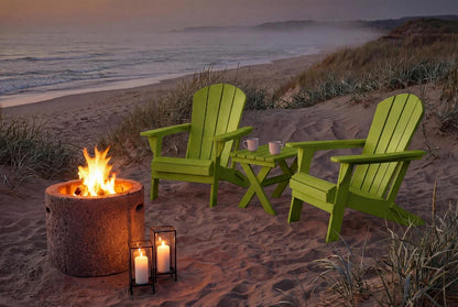 Two green Adirondack chairs with a fire pit on a beach at sunset.