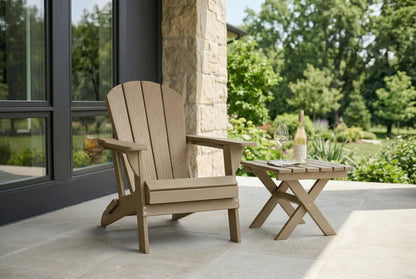 HDPE Adirondack chair and small table on a patio with a view of nature.