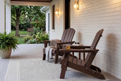 Two HDPE Adirondack chairs on a porch with a white brick wall and garden view.