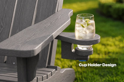 A gray Adirondack-style chair arm with a built-in cup holder, shown outdoors on grass with a clear glass of iced drink resting in the holder. Text overlay reads 'Cup Holder Design'.
