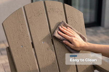 A close-up of a person wiping down a light brown outdoor chair with a gray cloth. The chair has a clean, weathered wood-look finish with water droplets on the surface.
