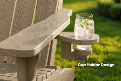 Close-up of a light brown outdoor Adirondack chair arm with a built-in cup holder, holding a clear glass of water with ice and lime slices. The background shows a blurred green lawn, and a text overlay reads 'Cup Holder Design'.