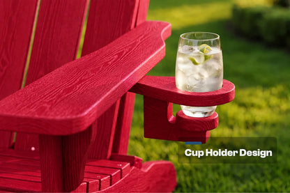 A red outdoor Adirondack-style chair with a built-in cup holder mounted on the armrest, holding a clear glass of iced water with lime slices. The background is a blurred green lawn, and the text 'Cup Holder Design' appears in the lower right corner.