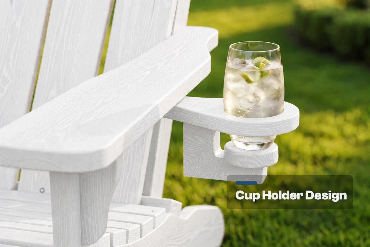 A white Adirondack-style chair arm with a built-in cup holder mounted on the side, holding a clear glass of iced drink outdoors on a grassy lawn. Text overlay reads 'Cup Holder Design'.