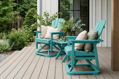 Two Aruba blue Adirondack chairs on a wooden deck with cushions and plants.