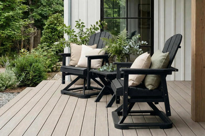 Two black Adirondack chairs with cushions on a wooden deck.