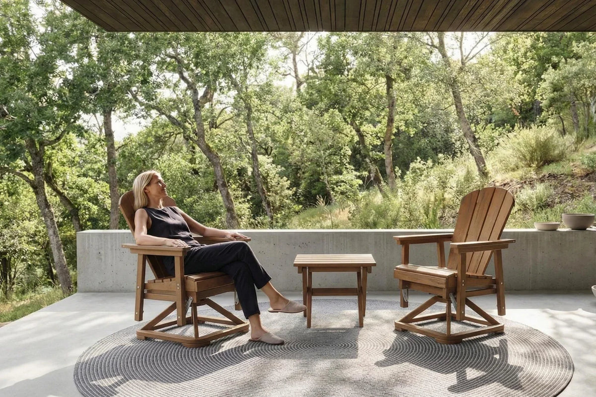 Woman sitting on a brown chair in a serene outdoor setting with trees and a clear sky.