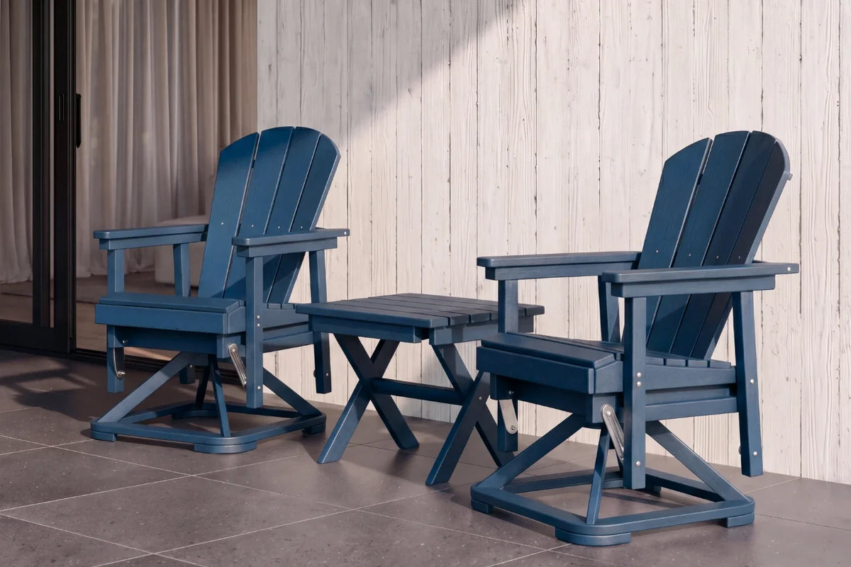 Two navy blue Adirondack chairs with a matching table on a wooden deck.