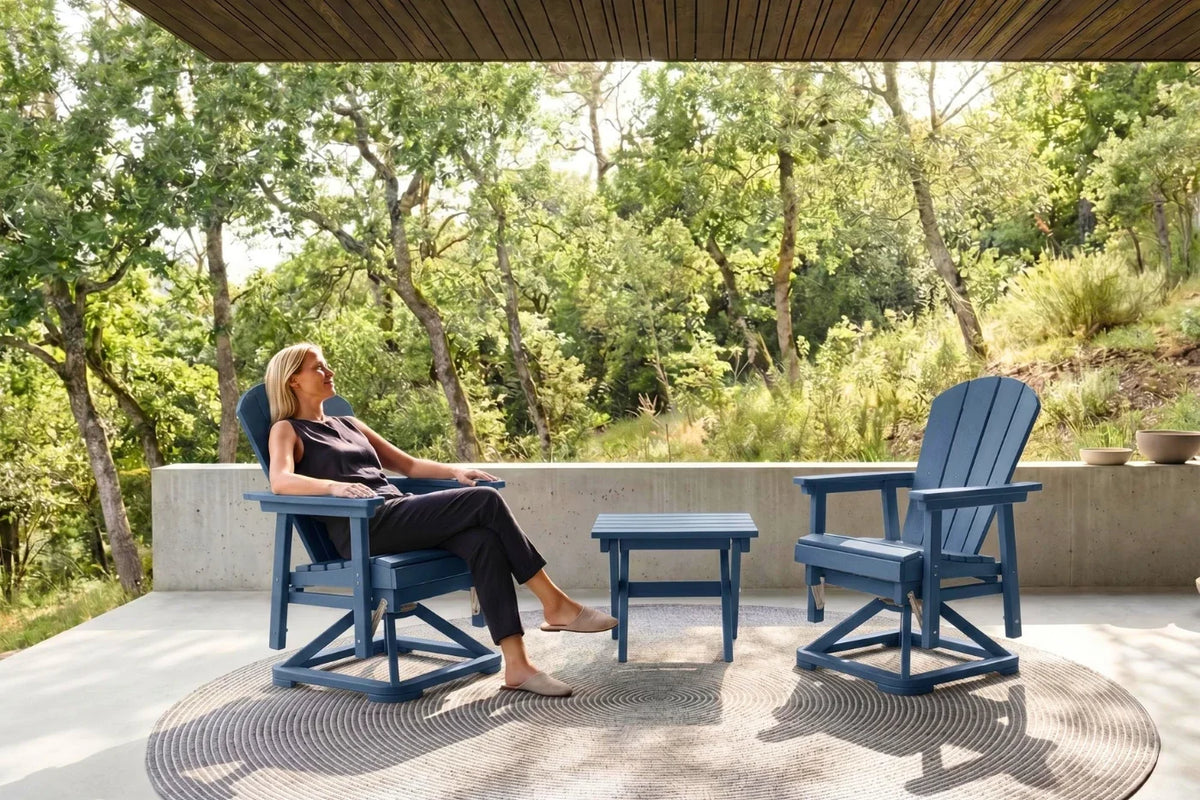 Woman sitting on a navy blue chair in a outdoor setting with trees and a clear sky.
