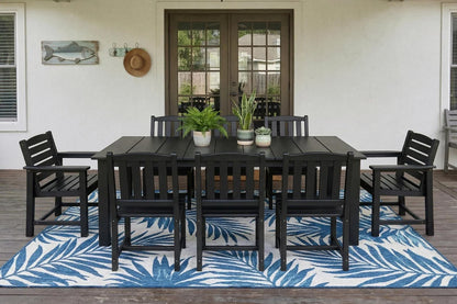 Outdoor dining set with black table and chairs on a blue and white patterned rug.