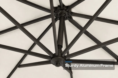 Close-up of a black aluminum patio umbrella frame with radiating ribs against a creamy white canopy background, with a text overlay reading 'Sturdy Aluminum Frame'.