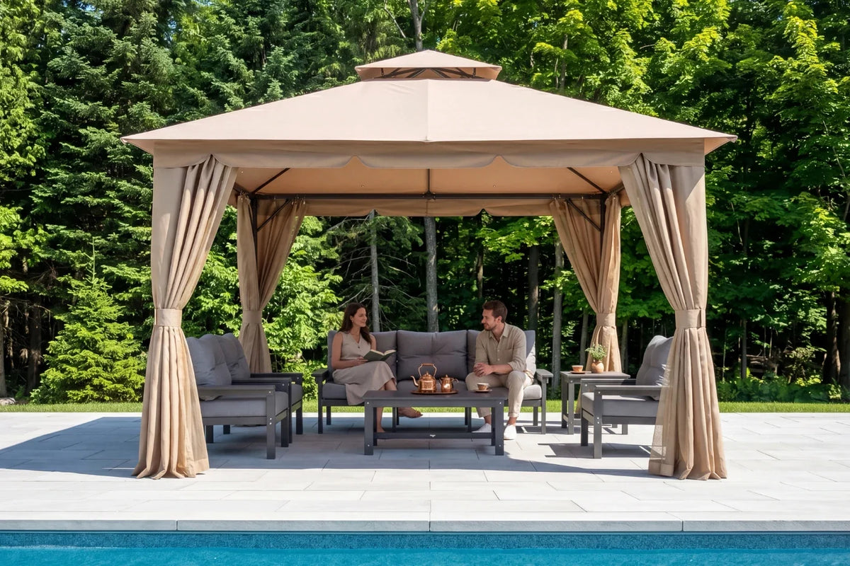 Two people sitting under a sand khaki gazebo by a pool with trees in the background