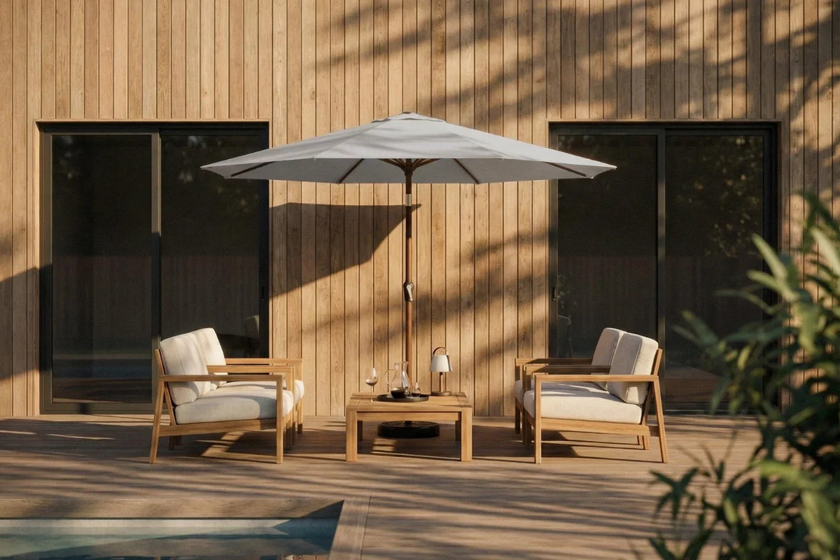 Outdoor patio set with two chairs, a table, and an umbrella against a wooden wall.