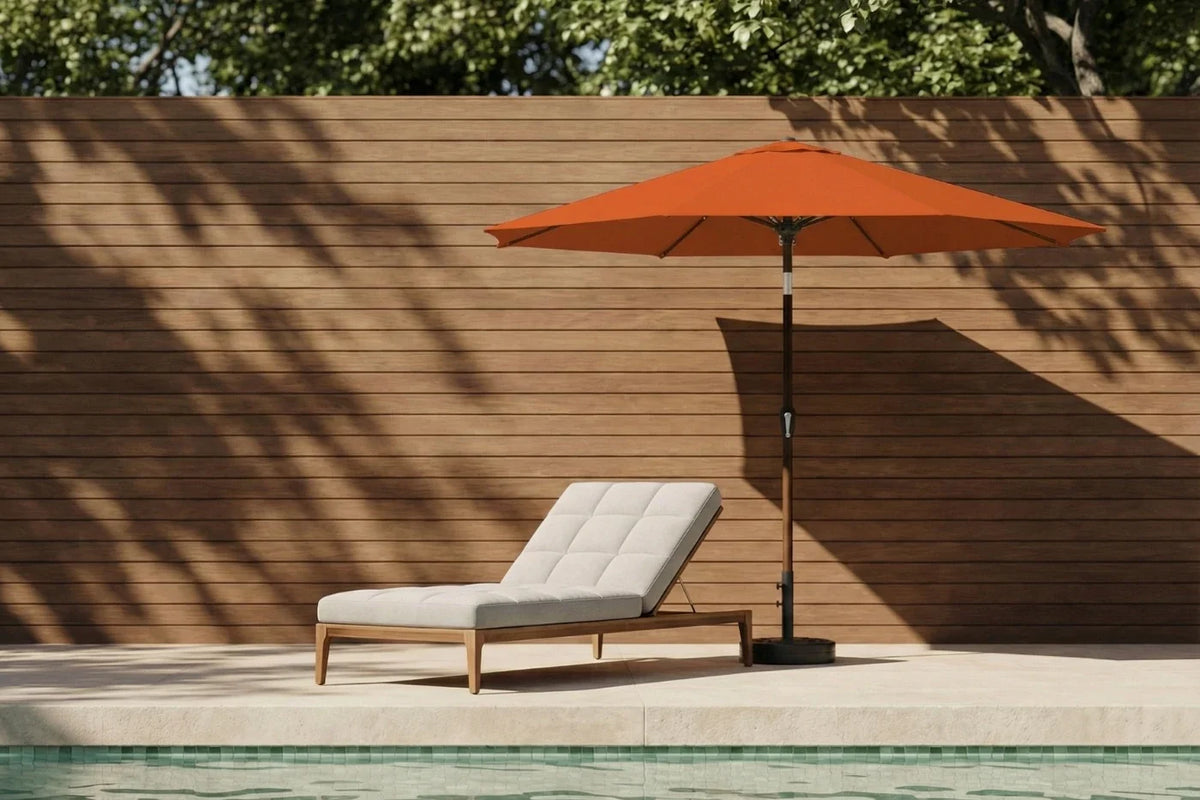 Orange patio umbrella and lounge chair by a poolside with wooden wall background
