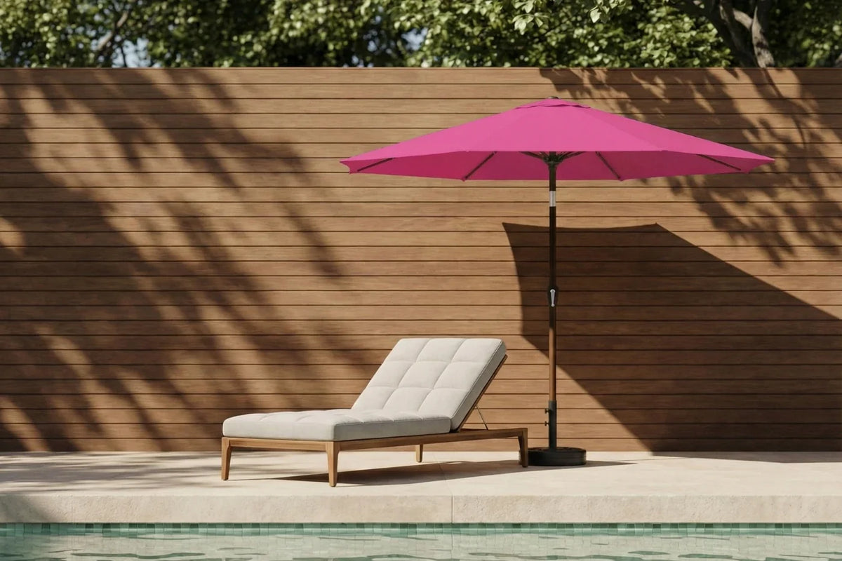 Pink patio umbrella and lounge chair by a poolside with wooden wall background