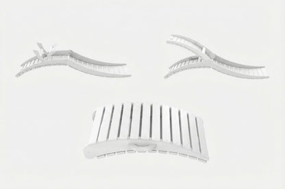 Set of white hair styling tools including a comb and clips on a light gray background