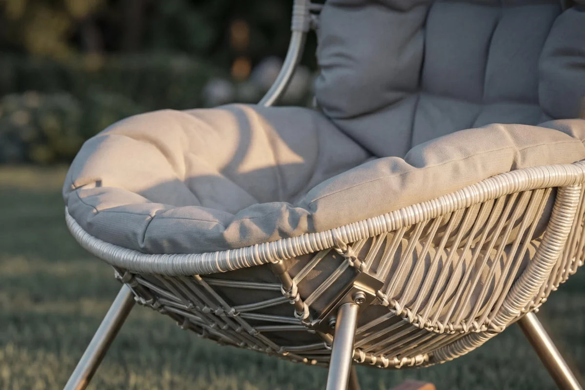 Wicker chair with gray cushions on a blurred outdoor background