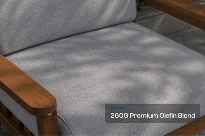 Close-up of a gray outdoor chair cushion with a brown frame, showing dappled sunlight and a text overlay that reads '260G Premium Olefin Blend'.